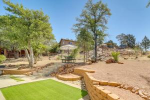 a backyard with a stone retaining wall and grass at Payson Summer Getaway w/ Backyard in Payson