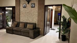 a living room with a couch and a brick wall at Adams Lodge F-7 in Islamabad