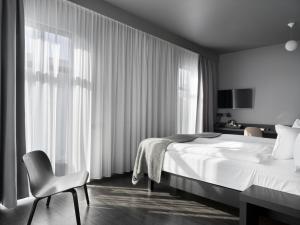 ein Schlafzimmer mit einem Bett, einem Stuhl und einem Fenster in der Unterkunft Skuggi Hotel by Keahotels in Reykjavík