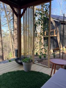 a screened in porch with a table and a patio at Treeangle Treehouse in Morganton +25 photos