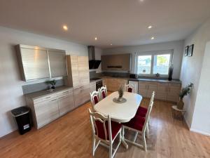a kitchen and dining room with a table and chairs at KC Appartments in Schwanau