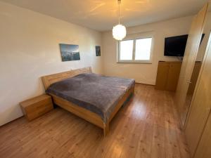 a bedroom with a bed and a flat screen tv at KC Appartments in Schwanau