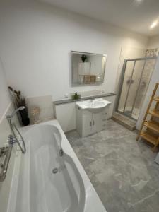 a white bathroom with a tub and a sink at KC Appartments in Schwanau