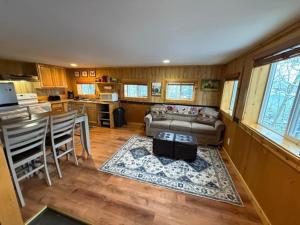 a living room with a couch and a table at Denali Park View Family Log Cabin in Healy +7 photos