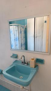 a bathroom with a blue sink and a mirror at Bed & Breakfast in El Gallinero