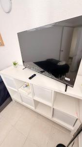 a white dresser with a large tv on top of it at Bed & Breakfast in El Gallinero