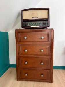 a wooden dresser with a radio on top of it at Comme en 40 in La Lande-sur-Drôme
