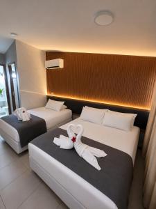 two beds in a hotel room with towels on them at Nannai Beira Mar, Flat Duplex em Muro Alto - Porto de Galinhas in Porto De Galinhas +66 photos