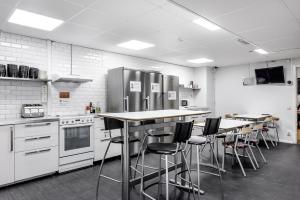 una cocina con taburetes y electrodomésticos de acero inoxidable en City Hostel en Estocolmo