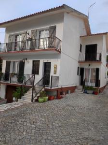 a white house with stairs and balconies on it at Comfort Beach house in Nazaré