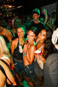 a group of women standing in a crowd at a party at Raindance Hostel in Santa Cruz