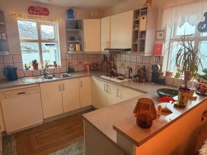 a kitchen with white cabinets and a counter top at Nýlenda - Charming Two Bedroom Seaside Property, Mountain and Town Views in Seyðisfjörður