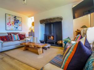 a living room with a couch and a fireplace at Cefn Nannau in Corwen
