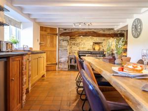 a large kitchen with a long wooden table and chairs at Cefn Nannau in Corwen