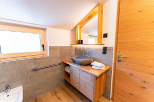 a bathroom with a sink and a mirror at AurAlpin Apartments in Cadipietra +34 photos