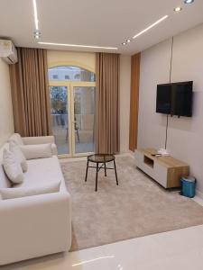 a living room with a white couch and a flat screen tv at Tamaya Hotel, Fifth Settlement, New Cairo in Cairo +20 photos
