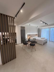 a living room with a table and chairs and a bed at Almondo Suites in Amigdhaleón +76 photos