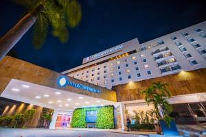 a hotel with a building with a palm tree at Hotel Intercontinental Cali by IHG in Cali