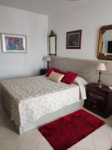 a bedroom with a large bed and a red rug at Comfort Beach house in Nazaré +43 photos