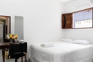 a bedroom with a bed and a desk and a window at Hotel pousada czar in João Pessoa