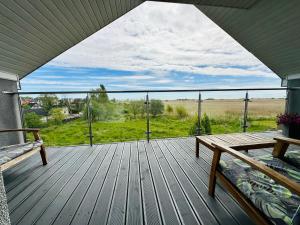 a deck with a bench and a view of a field at Willa Dobryłko II -Apartamenty in Rewa