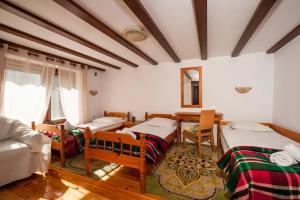 a room with four beds and a couch in it at Вила Соколето in Sokolovtsi