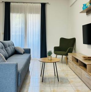 a living room with a couch and a table and a chair at Sunny Siviri in Siviri