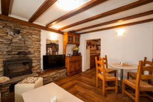 a living room with a fireplace and a table and chairs at Вила Соколето in Sokolovtsi
