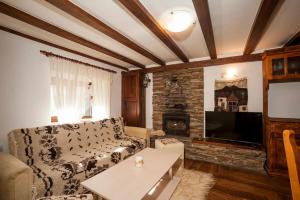 a living room with a couch and a tv at Вила Соколето in Sokolovtsi +16 photos