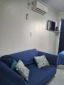 a blue couch in a living room with pillows on it at Luminoso monoambiente con cochera propia dentro del edificio in La Plata