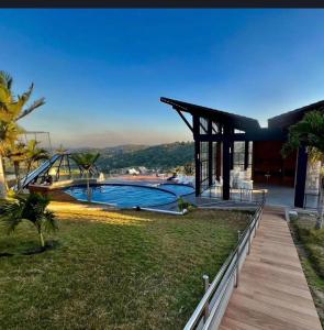a house with a swimming pool and a wooden deck at A casa do vale in Bananeiras