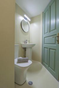 a bathroom with a toilet and a sink and a mirror at Faros Coastal Apartments in Skopelos Town +25 photos