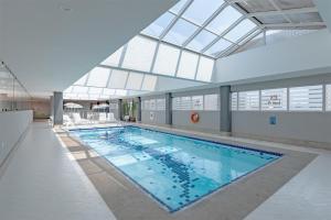 a large swimming pool in a building with a glass ceiling at Bristol International Guarulhos in Guarulhos