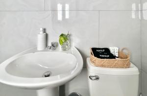 a white bathroom with a sink and a toilet at Grace Studio Roatan in Coxen Hole