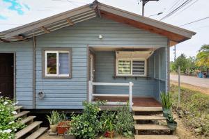 a blue tiny house with a porch and stairs at Grace Studio Roatan in Coxen Hole