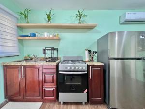a kitchen with a stove and a stainless steel refrigerator at Grace Studio Roatan in Coxen Hole +5 photos