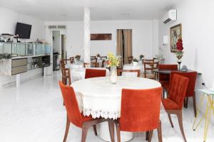 a dining room with a white table and chairs at Hotel pousada czar in João Pessoa