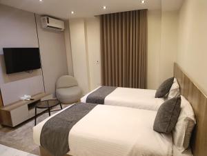 a hotel room with two beds and a television at Tamaya Hotel, Fifth Settlement, New Cairo in Cairo