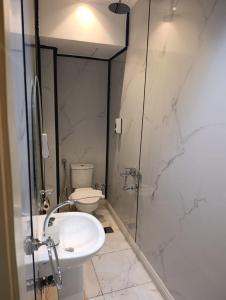 a bathroom with a toilet and a sink and a shower at Tamaya Hotel, Fifth Settlement, New Cairo in Cairo