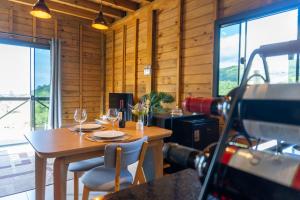 a dining room with a table and chairs and windows at Chalé em laguna in Pescaria Brava +2 photos