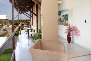 a living room with a chair and a table at Hotel pousada czar in João Pessoa