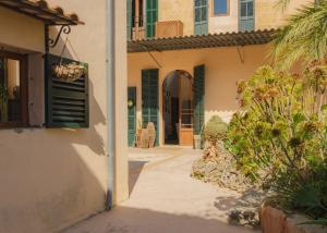 an alleyway leading to a house with green shutters at Casa Mona, Turismo de Interior in Llubí