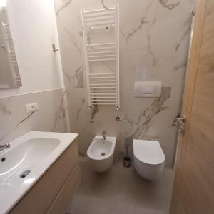 a white bathroom with a sink and a toilet at Casa Penasa App 3 in Commezzadura +27 photos