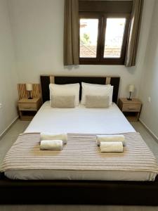 a bedroom with a large bed with two pillows at Sunny Siviri in Siviri