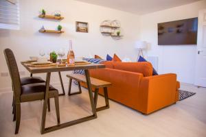 a living room with a orange couch and a table at The Wee Shore House in Ayr