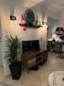 a living room with a tv and a clock on the wall at 7th sky Aristotelous in Thessaloniki