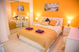 a bedroom with a large bed with two mirrors at The Wee Shore House in Ayr
