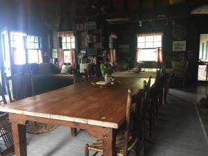 a wooden table and chairs in a room with windows at Wishart Point Lodge in Neguac +16 photos