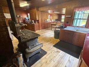 a large kitchen with a stove in the middle at Wishart Point Lodge in Neguac