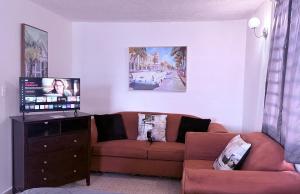 a living room with a couch and a flat screen tv at Comfortable Apartment in the Greater Ponce Area in Ponce